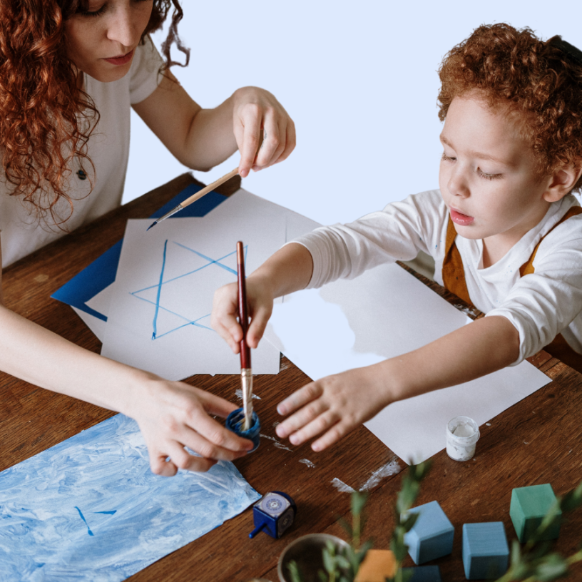 Woman showing child how to paint