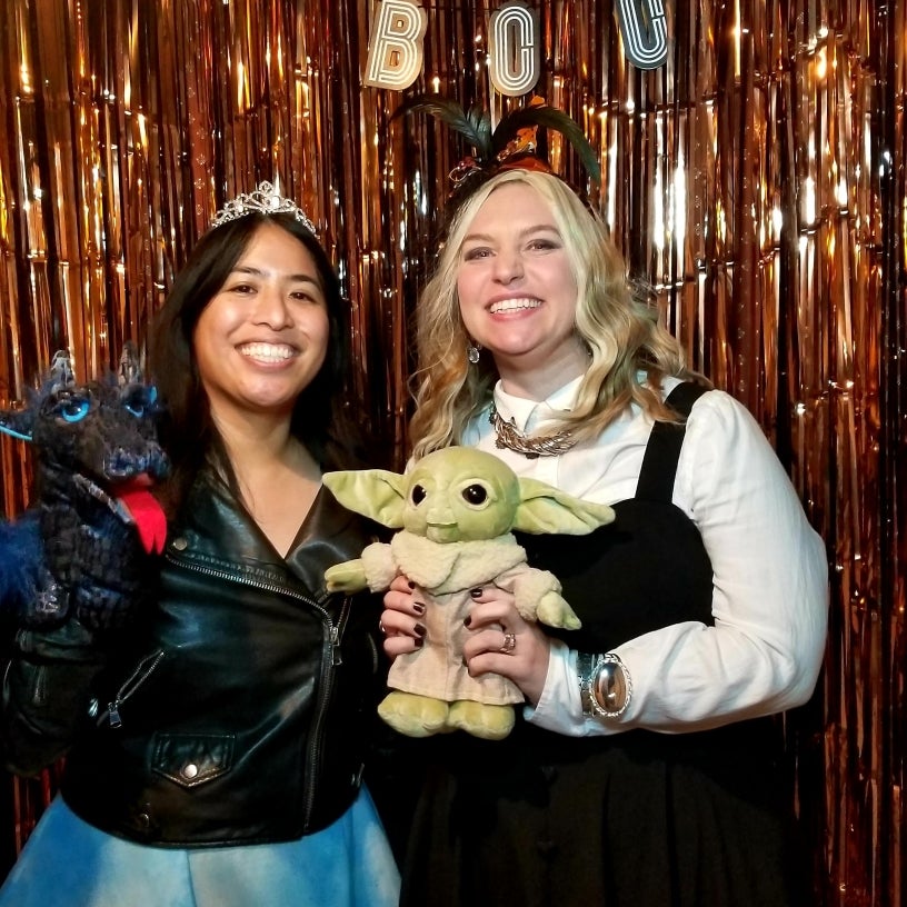 Photo of librarians holding Baby Yoda 