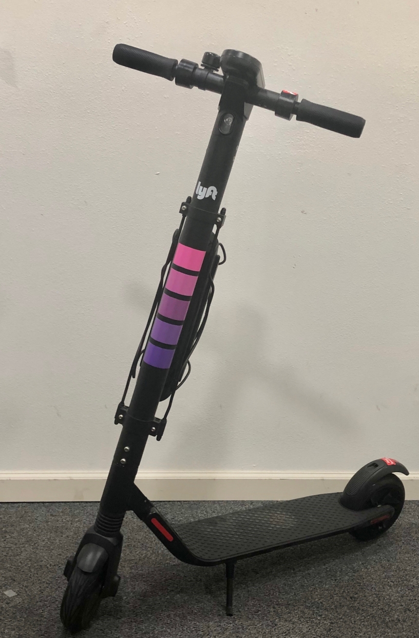 Picture of a black Lyft scooter with pink tire rims.