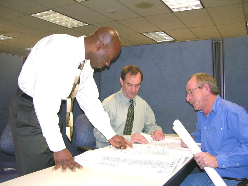 Three men reviewing plans