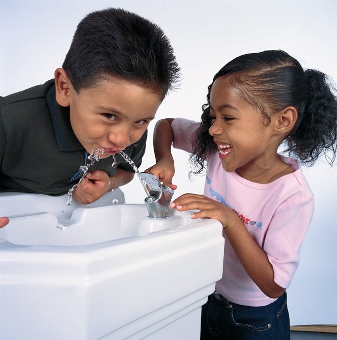 Two kids at a drinking fountain