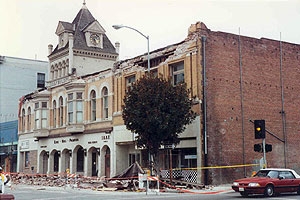 An earthquake-damaged unreinforced masonry building with its parapets collapsed onto the sidewalk.