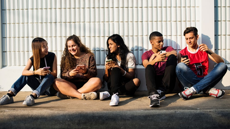 Group of social teenagers with smartphones