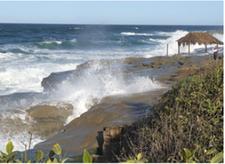 Photo of waves crashing on beachside cliffs