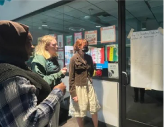 Three teens brainstorming around an easel