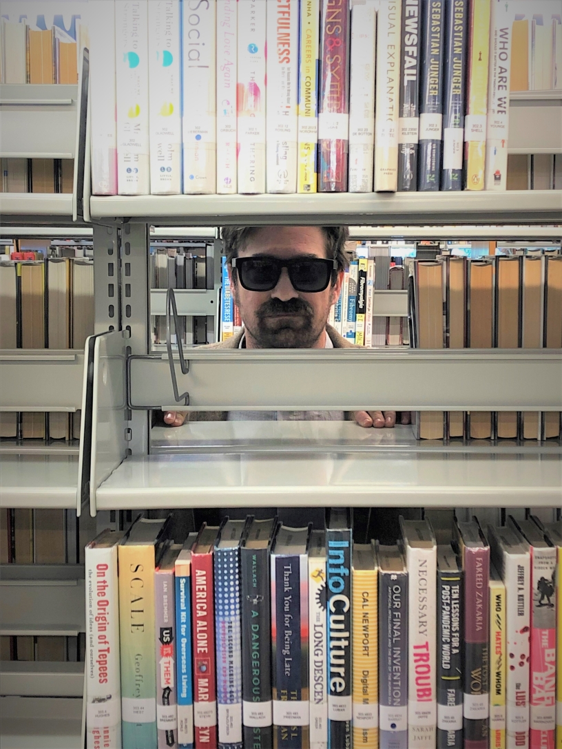 Librarian peeing out from behind the shelves