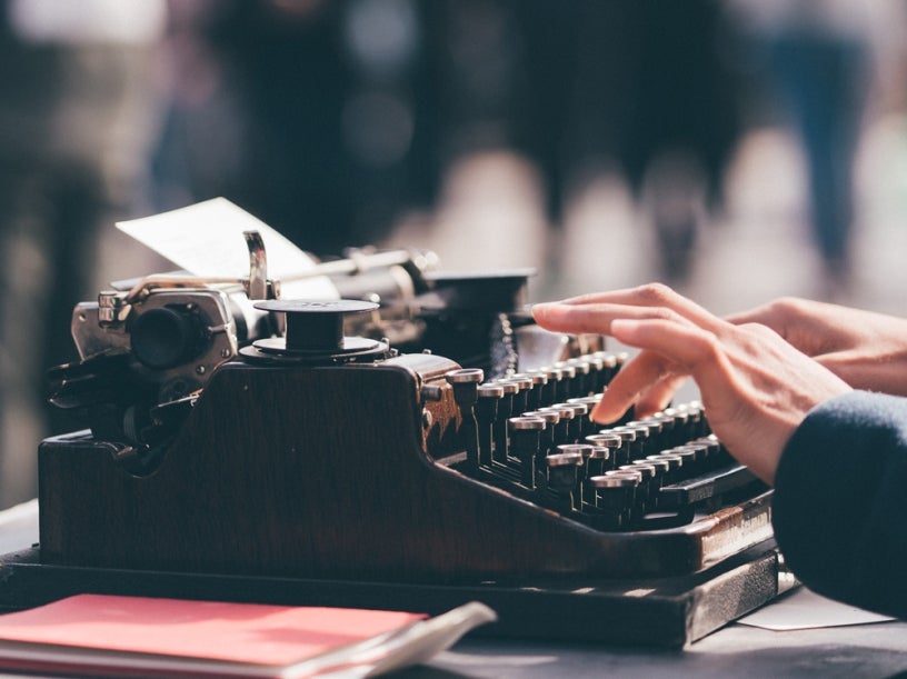 Photo of person typing on a typewriter
