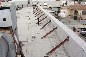 Steel diagonal braces secure roof parapets on unreinforced masonry block.