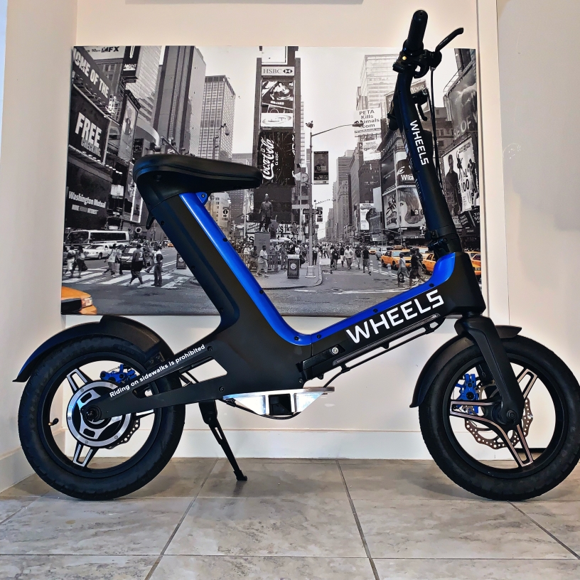 A blue and black electric bicycle from Wheels. 
