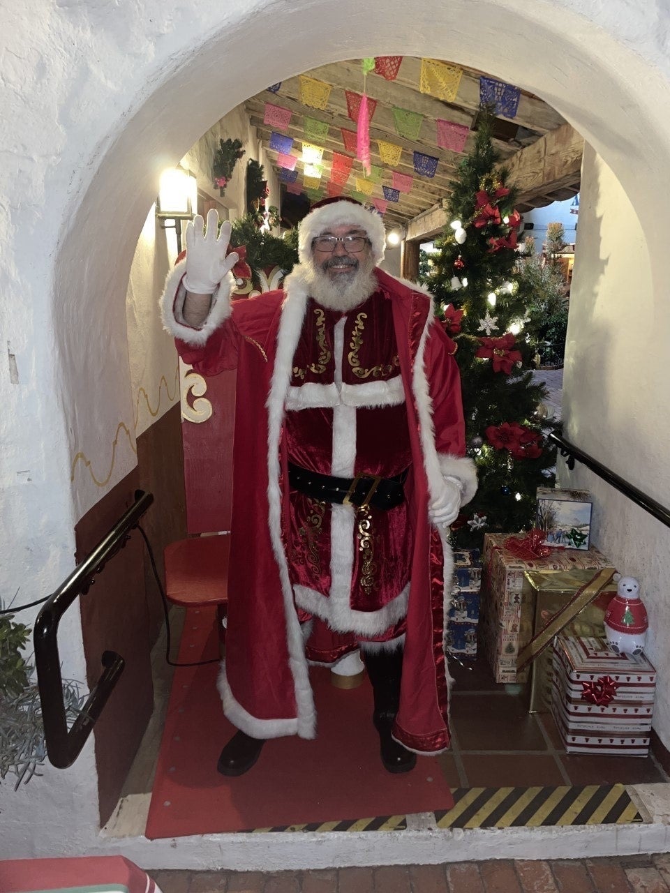 Man dressed in Santa costume with red robe.