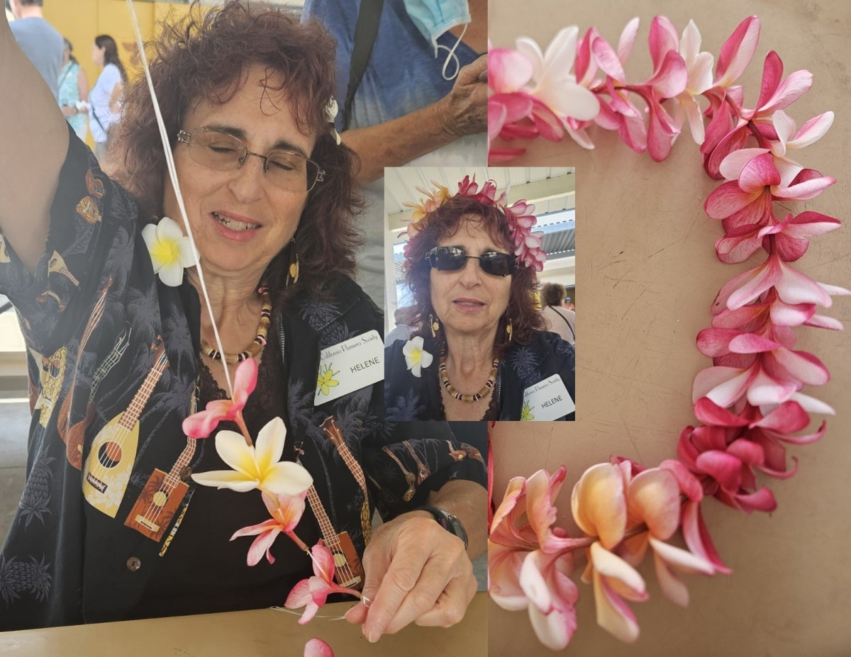 Woman hand-sewing a flower lei.