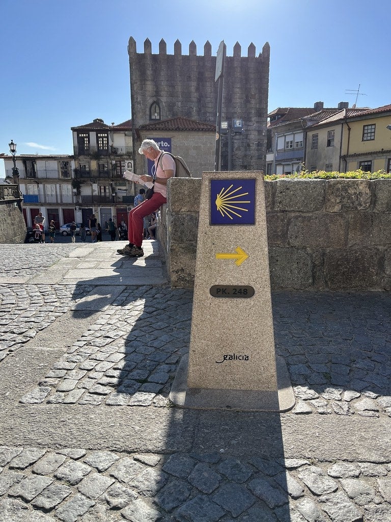 Man reading newspaper in old Spanish town