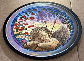 Circular painting of a sleeping cherub. Artist Maggie Yang