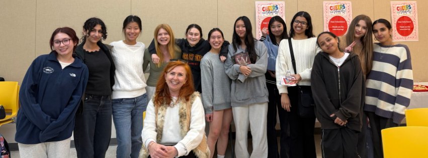 A group of 12 teenagers pose for a photo with a SDPL librarian.