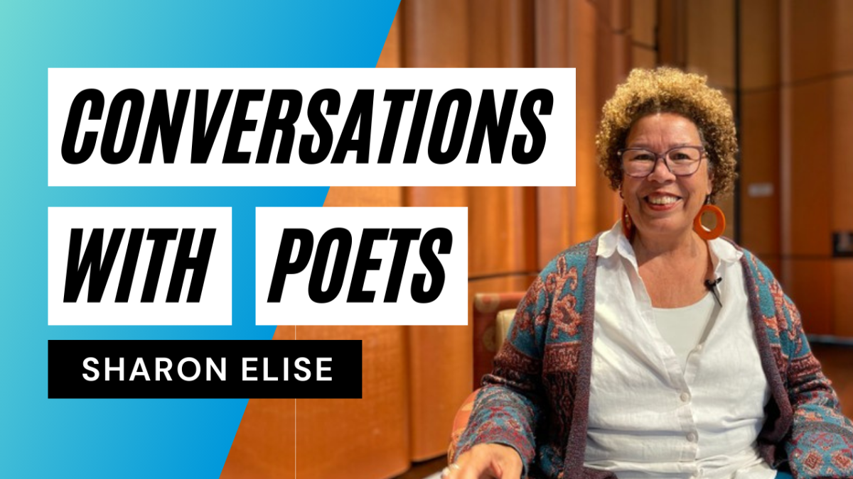 A Black woman smiles at the camera while seated at the Neil Morgan Auditorium stage at Central Library.