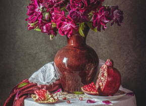 Detail of a still life photograph of a vase of flowers and fruit on a table