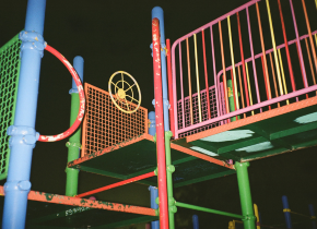 Photograph of a colorful children's play structure at night