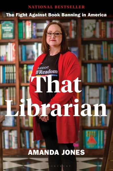 The cover features a photo of the author standing in front of a book shelf, wearing glasses and a red sweater.
