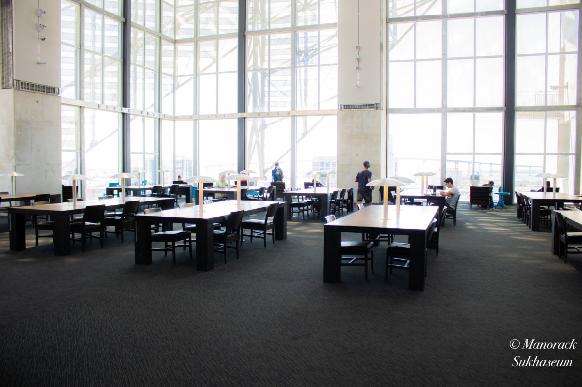 Helen Price Reading Room: Room with large glass windows and large wooden tables with a few chairs