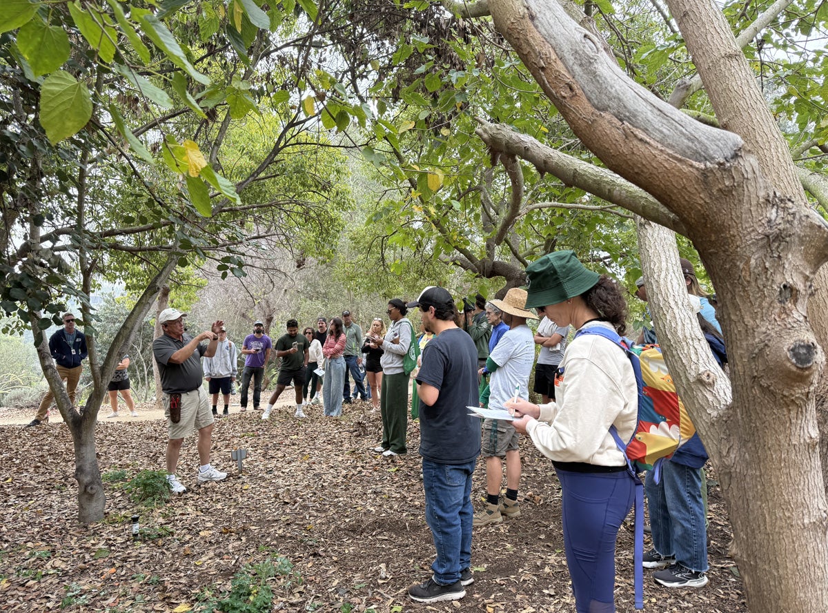 Tour guide and group in wooded area