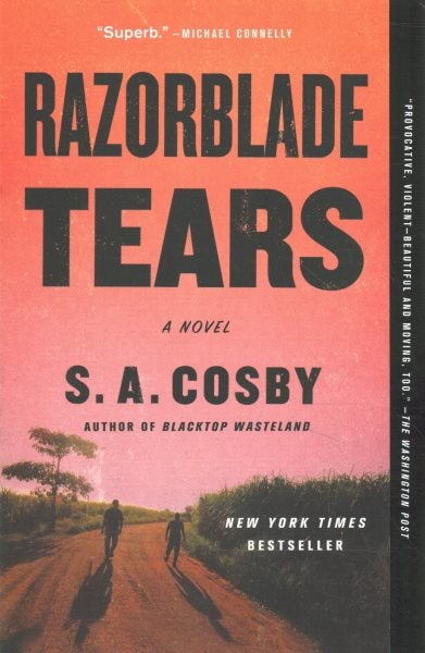 The cover features two darkened figures walking down a dirt path. Tall grass is lining the path, and there is a tree on one side. The sky is red.