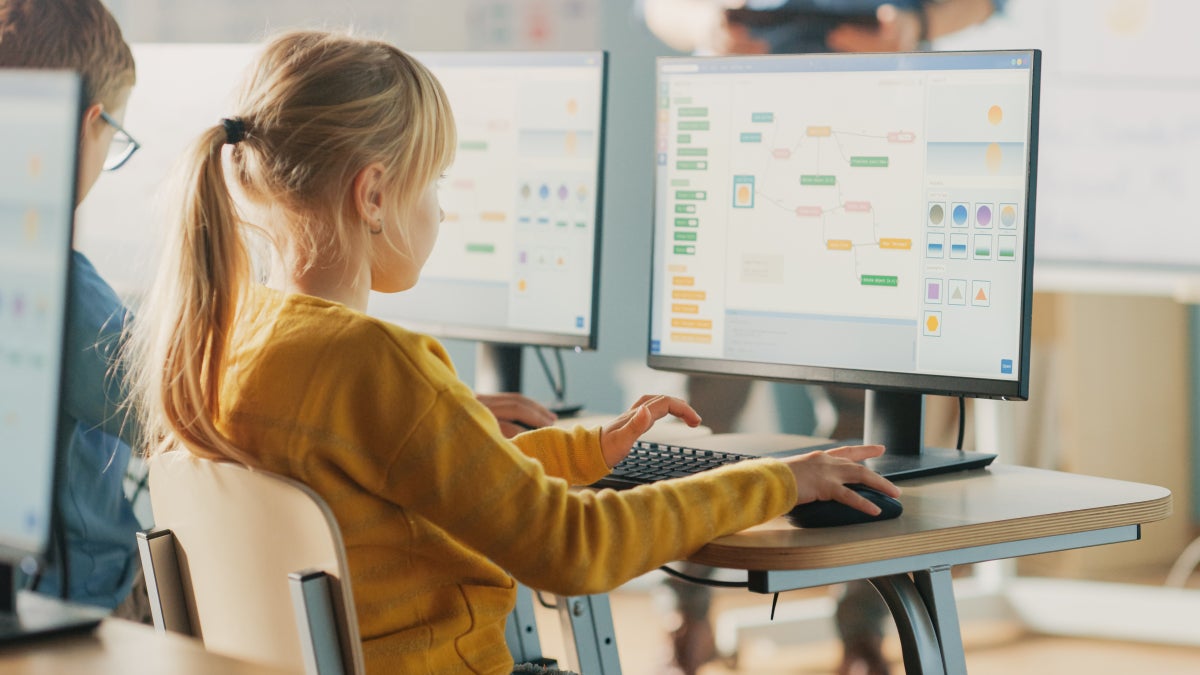 Young girl facing a computer and interacting with the Scratch program. 
