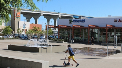 Child on a scooter at a strip mall in Barrio Logan