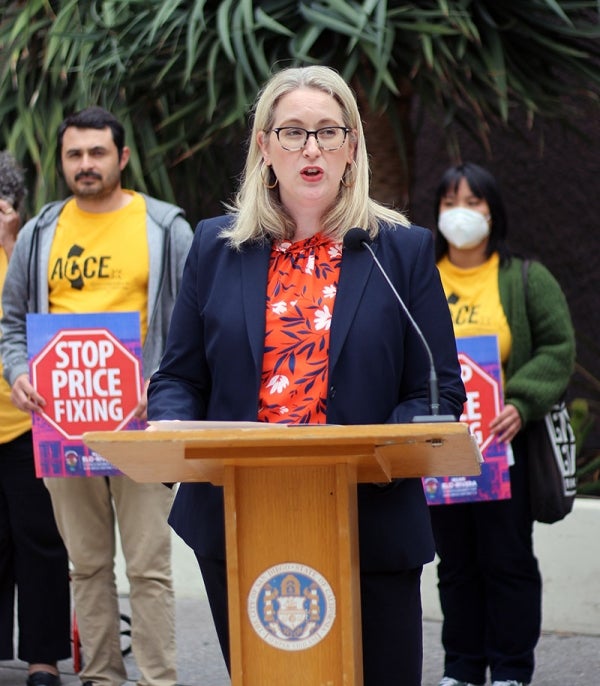 City Attorney Heather Ferbert speaking at a press conference behind a podium
