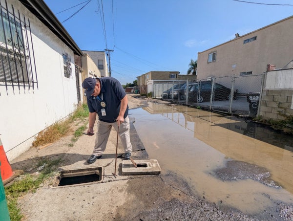 Code enforcement employee accessing a meter in an alley