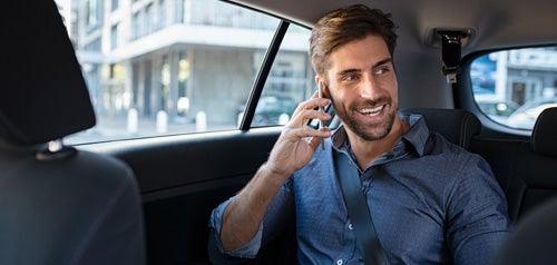 Man on the phone riding in backseat of a car