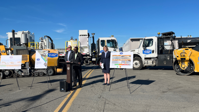 City staff talking during a press conference surrounded by City trucks