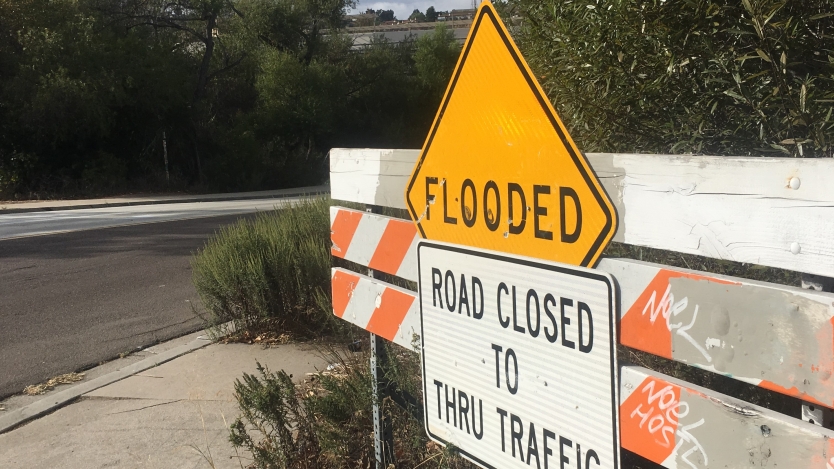 flooded sign on barricade located on the sidewalk 
