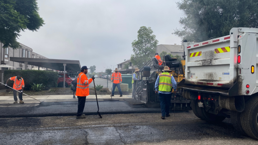 five transportation team members working on resurfacing road