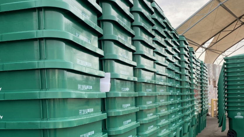 green recycling bins stacked in rows