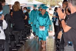 career online high school graduates walking down an aisle, surrounded by cheering people