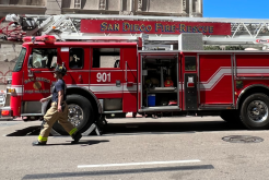side view of a fire truck with a firefighter walking by