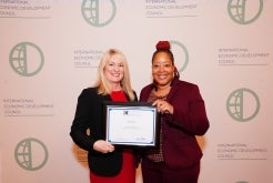 Two city employees holding award