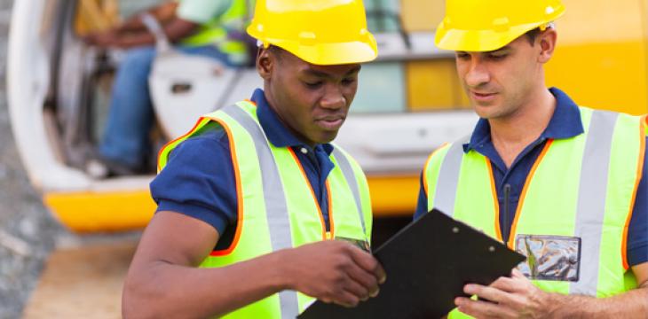 Photo of Construction Workers Looking at Permits