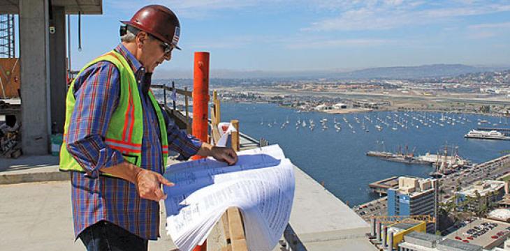 Construction worker reviewing plans in a building being constructed in downtown San Diego