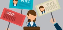 Candidate at Podium with VOTE Signs