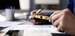 A person using a magnifying glass to read a document