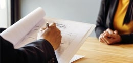 A person writing on a document during an interview