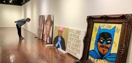 gallery with paintings leaning against wall