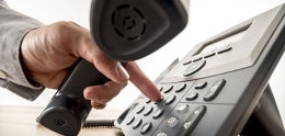 Photo of Close up of Hand Dialing a Telephone