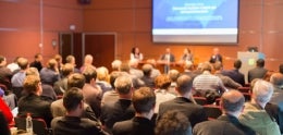 Photo of Audience Listening to a Panel on Stage
