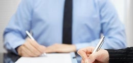 Photo of Man and Woman Writing on Documents