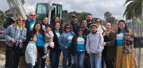 Members of the Environmental Health Coalition posing in front of a construction site