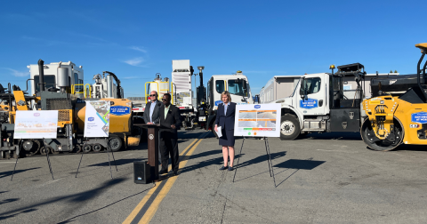 City staff talking during a press conference surrounded by City trucks