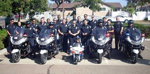 Group photo of police officers behind police motorcycles