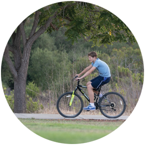 Teenager riding his bike through the park